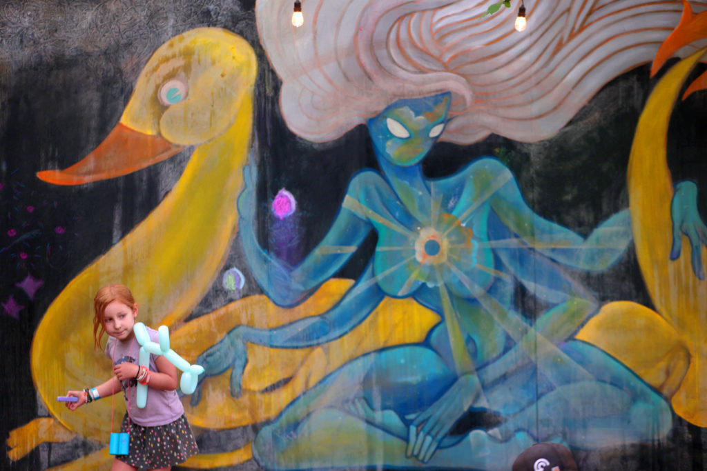 A young girl adds her touches to a large chalk painting by the artist Eatcho at the Pickathon music festival at Pendarvis Farm in Happy Valley, Ore. on Sunday, Aug. 6, 2023. Photo by James Glover II / @james_glover_photography
